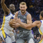 
              Sacramento Kings forward Domantas Sabonis is guarded by Golden State Warriors forward Draymond Green and Warriors guard Stephen Curry during the second half of an NBA basketball game in Sacramento, Calif., Sunday, Nov. 13, 2022. The Kings won 122-115. (AP Photo/Randall Benton)
            
