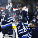 
              Winnipeg Jets' Kyle Connor (81) and goaltender Connor Hellebuyck (37) celebrate the team's overtime win against the Montreal Canadiens in an NHL hockey game Thursday, Nov. 3, 2022, in Winnipeg, Manitoba. (John Woods/The Canadian Press via AP)
            