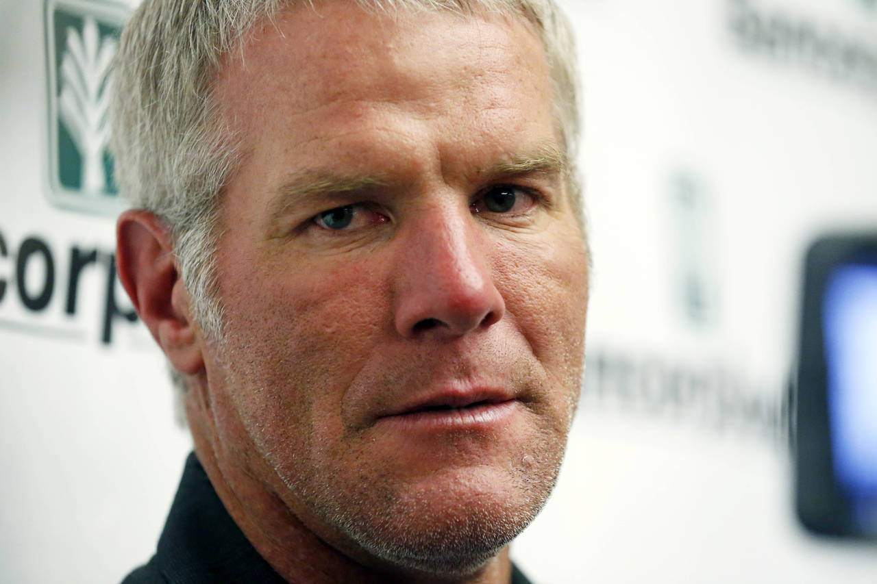 FILE - Former NFL football quarterback Brett Favre speaks with reporters prior to his induction to ...