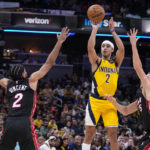 
              Indiana Pacers guard Andrew Nembhard (2) shoots over Miami Heat guard Gabe Vincent (2) and guard Duncan Robinson (55) during the second half of an NBA basketball game in Indianapolis, Friday, Nov. 4, 2022. The Pacers defeated the Heat 101-99. (AP Photo/Michael Conroy)
            