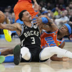 
              Oklahoma City Thunder's Shai Gilgeous-Alexander, right, reaches for the ball held by Milwaukee Bucks' George Hill (3) during the first half of an NBA basketball game Wednesday, Nov. 9, 2022, in Oklahoma City. (AP Photo/Sue Ogrocki)
            