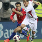 
              FILE —  Voria Ghafouri, right, then an Iranian national team soccer player, challenges for a ball with Chile's Alexis Alejandro Sanchez during a friendly soccer match in St. Poelten, Austria, March 26, 2015. The semiofficial Fars and Tasnim news agencies reported on Thursday, Nov. 24, 2022, that Iran arrested Ghafouri, a prominent former member of its national soccer team for insulting the national soccer team, which is currently playing in the World Cup, and criticizing the government as authorities grapple with nationwide protests. (AP Photo/Ronald Zak, File)
            