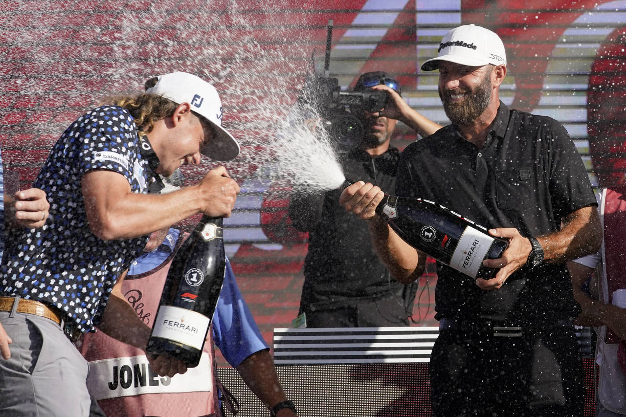 Cameron Smith, left, and Dustin Johnson, right,  celebrate after the final round of the LIV Golf Te...