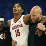 
              Alabama forward Noah Clowney (15) is helped off the court during the first half of the team's NCAA college basketball game against North Carolina in the Phil Knight Invitational on Sunday, Nov. 27, 2022, in Portland, Ore. (AP Photo/Rick Bowmer)
            