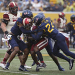 
              Oklahoma running back Eric Gray (0) is defended by West Virginia safety Marcis Floyd (24) during the first half of an NCAA college football game in Morgantown, W.Va., Saturday, Nov. 12, 2022. (AP Photo/Kathleen Batten)
            