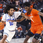 
              UCLA guard Tyger Campbell (10) drives against Illinois guard Sencire Harris during the second half of an NCAA college basketball game Friday, Nov. 18, 2022, in Las Vegas. (AP Photo/Chase Stevens)
            