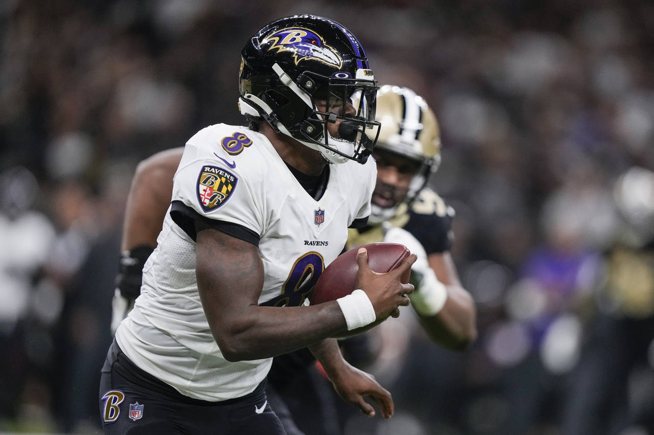 Baltimore Ravens quarterback Lamar Jackson (8) scrambles away from the New Orleans Saints defense i...