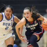 
              Connecticut guard Nika Muhl (10) brings the ball upcourt as Duke guard Vanessa de Jesus (2) defends during the first half of an NCAA college basketball game in the Phil Knight Legacy tournament Friday, Nov. 25, 2022, in Portland, Ore. (AP Photo/Rick Bowmer)
            