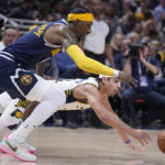 
              Denver Nuggets' Kentavious Caldwell-Pope, top, and Indiana Pacers' Andrew Nembhard scramble for the ball during the first half of an NBA basketball game Wednesday, Nov. 9, 2022, in Indianapolis. (AP Photo/Darron Cummings)
            