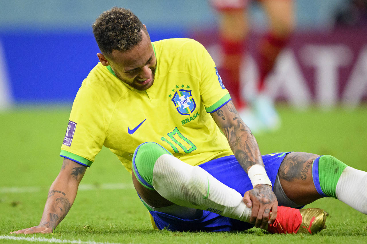 Brazil's Neymar grabs his ankle after an injury during the World Cup group G soccer match between B...