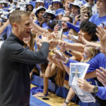 
              Duke head coach Jon Scheyer greets fans in the Duke student section after earning his first win as head coach of the Blue Devils in an NCAA college basketball game against Jacksonville in Durham, N.C., Monday, Nov. 7, 2022. (AP Photo/Ben McKeown)
            