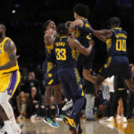 
              Indiana Pacers guard Andrew Nembhard, second from right, celebrates with teammates after making a buzzer beating 3-point shot to win the game as Los Angeles Lakers forward LeBron James walks off the court during the second half of an NBA basketball game Monday, Nov. 28, 2022, in Los Angeles. The Pacers won 116-115. (AP Photo/Mark J. Terrill)
            