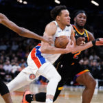 
              Detroit Pistons' Kevin Knox II (20) drives to the basket between Phoenix Suns' Mikal Bridges (25) and Josh Okogie (2) during the first half of an NBA basketball game in Phoenix, Friday, Nov. 25, 2022. (AP Photo/Darryl Webb)
            