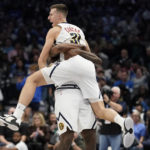 
              Denver Nuggets forward Vlatko Cancar (31) gets lifted by teammate DeAndre Jordan after Cancar scored a 3-pointer at the end of the first half of an NBA basketball game against the Dallas Mavericks in Dallas, Sunday, Nov. 20, 2022. The Nuggets won 98-97. (AP Photo/LM Otero)
            