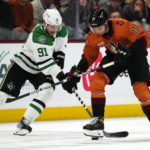 
              Arizona Coyotes right wing Dylan Guenther (11) and Dallas Stars center Tyler Seguin (91) vie for the puck during the third period of an NHL hockey game in Tempe, Ariz., Thursday, Nov. 3, 2022. The Stars won 7-2. (AP Photo/Ross D. Franklin)
            