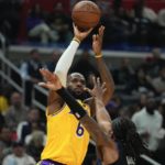 
              Los Angeles Lakers forward LeBron James, top, shoots as Los Angeles Clippers guard Terance Mann defends during the first half of an NBA basketball game Wednesday, Nov. 9, 2022, in Los Angeles. (AP Photo/Mark J. Terrill)
            