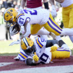 
              LSU running back Josh Williams (27) leaps over teammate Emery Jones Jr. (50) as he scores a touchdown against Arkansas during the second half of an NCAA college football game Saturday, Nov. 12, 2022, in Fayetteville, Ark. (AP Photo/Michael Woods)
            