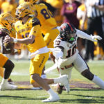 
              Arizona State quarterback Trenton Bourguet, left, runs past Oregon State linebacker Andrew Chatfield Jr. during the first half of an NCAA college football game in Tempe, Ariz., Saturday, Nov. 19, 2022. (AP Photo/Ross D. Franklin)
            