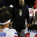 
              Eric Nelson, center, talks with his son, Los Alamitos High School quarterback Malachi Nelson, left, and wide receiver Makai Lemon on the sideline during a high school football game against Newport Harbor High School on Friday, Sept. 30, 2022, in Newport Beach, Calif. (AP Photo/Ashley Landis)
            