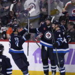 
              Winnipeg Jets' Blake Wheeler (26) celebrates his goal against the Colorado Avalanche with Mark Scheifele (55) and Neal Poink (4) during the third period of an NHL hockey game Tuesday, Nov. 29, 2022, in Winnipeg, Manitoba. (Fred Greenslade/The Canadian Press via AP)
            