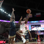
              Houston's Marcus Sasser (0) goes up for a shot as Oral Roberts's Nate Clover III (13) defends during the second half of an NCAA college basketball game Monday, Nov. 14, 2022, in Houston. (AP Photo/David J. Phillip)
            