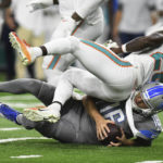 
              Miami Dolphins cornerback Kader Kohou (28) falls over Detroit Lions quarterback Jared Goff (16) during the second half of an NFL football game, Sunday, Oct. 30, 2022, in Detroit. (AP Photo/Lon Horwedel)
            