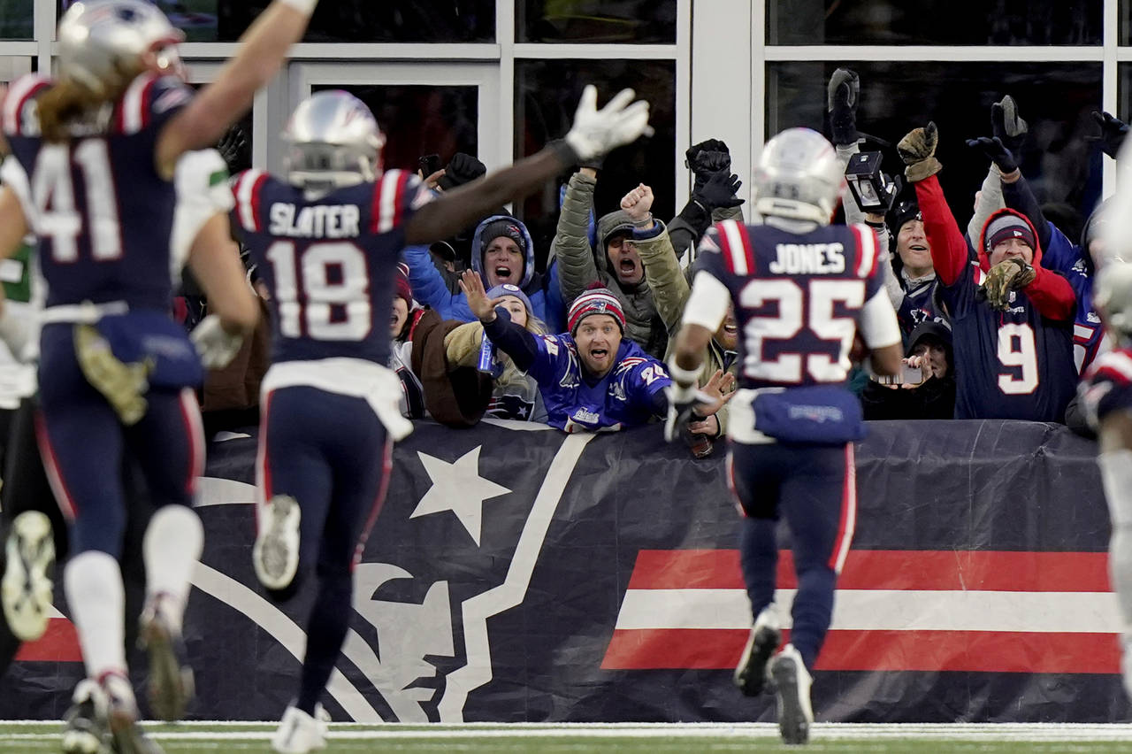 New England Patriots fans celebrate as cornerback Marcus Jones (25) scores on a punt return during ...