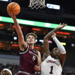 
              Bellarmine guard Peter Suder (5) shoots over Louisville guard Mike James (1) during the first half of an NCAA college basketball game in Louisville, Ky., Wednesday, Nov. 9, 2022. (AP Photo/Timothy D. Easley)
            