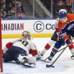 
              Florida Panthers goalie Spencer Knight, left, makes a save against Edmonton Oilers' Zach Hyman (18) during second-period NHL hockey game action in Edmonton, Alberta, Monday, Nov. 28, 2022. (Jason Franson/The Canadian Press via AP)
            