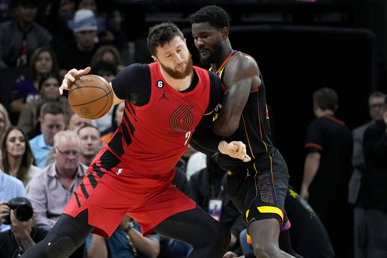 Portland Trail Blazers center Jusuf Nurkic is fouled by Phoenix Suns center Deandre Ayton, right, d...