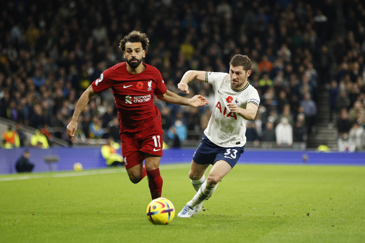 Liverpool's Mohamed Salah, left, challenges for the ball with Tottenham's Ben Davies during the Eng...
