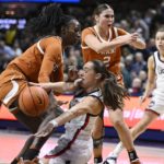 
              Connecticut's Nika Muhl, center, passes under pressure from Texas' Amina Muhammad, left, during the first half of an NCAA college basketball game, Monday, Nov. 14, 2022, in Storrs, Conn. (AP Photo/Jessica Hill)
            