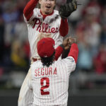 
              Philadelphia Phillies shortstop Bryson Stott and second baseman Jean Segura celebrate their win in Game 3 of baseball's World Series between the Houston Astros and the Philadelphia Phillies on Tuesday, Nov. 1, 2022, in Philadelphia. The Phillies won 7-0 to take one game lead in the best of seven series. (AP Photo/David J. Phillip)
            