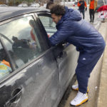 
              Michigan running back Blake Corum delivers to a car a tray containing a turkey, vegetables and other items during a giveaway event outside a school in Ypsilanti, Mich., on Sunday, Nov. 20, 2022. Corum took part in the charitable effort a day after hurting his knee and less than a week before his third-ranked Wolverines play No. 2 Ohio State. (AP Photo/Mike Householder)
            