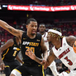 
              Louisville guard El Ellis (3) attempts to get past Appalachian State guard Tyree Boykin (30) during the second half of an NCAA college basketball game in Louisville, Ky., Tuesday, Nov. 15, 2022. (AP Photo/Timothy D. Easley)
            