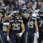 
              Seattle Seahawks running back Travis Homer (25) celebrates his touchdown with teammates during the second half of an NFL football game Sunday, Nov. 27, 2022, in Seattle. (AP Photo/Gregory Bull)
            