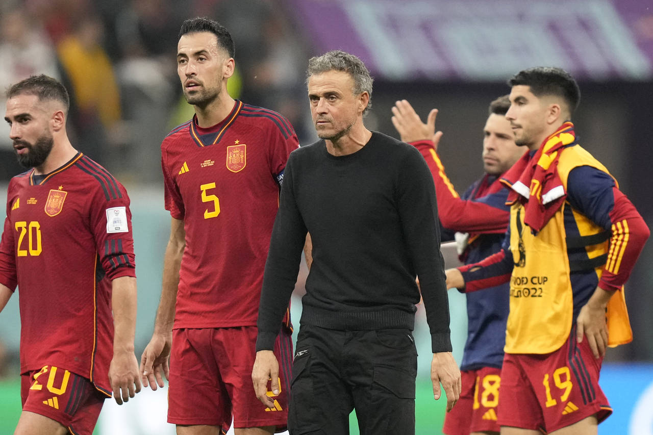 Spain's head coach Luis Enrique walks off the pitch with the players at the end of the World Cup gr...