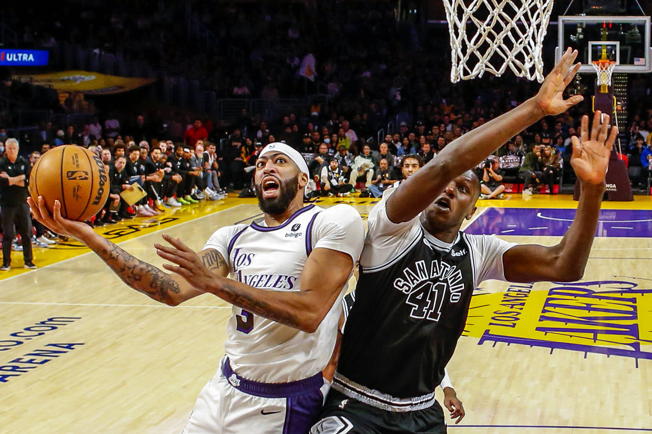 Los Angeles Lakers forward Anthony Davis, left, shoots under pressure from San Antonio Spurs forwar...