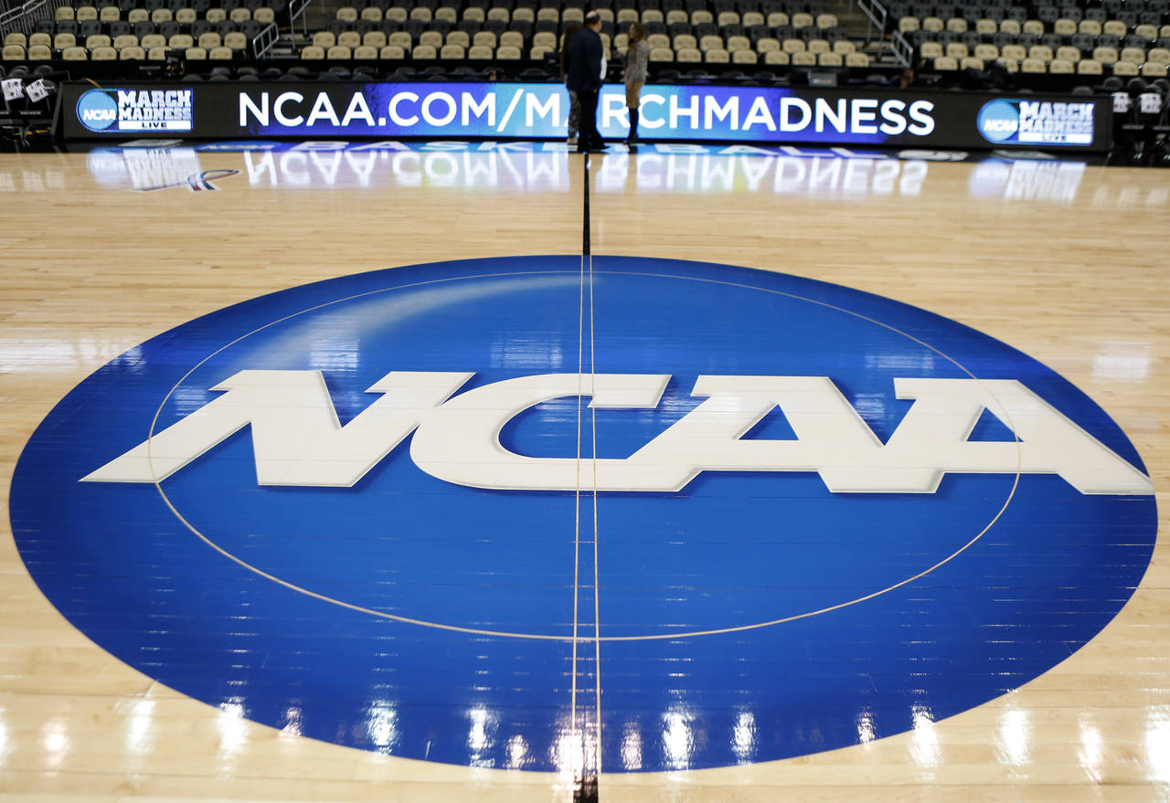 FILE - In this March 18, 2015, file photo, an NCAA logo is displayed at center court as work contin...