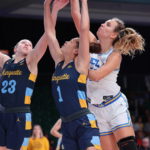 
              In a photo provided by Bahamas Visual Services, Marquette's Nia Clarke (1) and Liza Karlen (23) go for the ball against UCLA's Emily Bessoir, right, during the NCAA college basketball championship game in the Battle 4 Atlantis at Paradise Island, Bahamas, Monday, Nov. 21, 2022. (Tim Aylen/Bahamas Visual Services via AP)
            