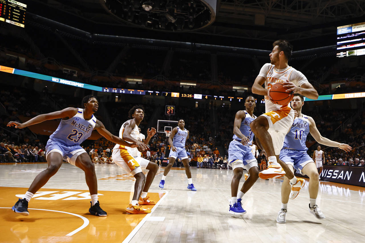 Tennessee guard Santiago Vescovi (25) passes the ball off as he's defended by McNeese State forward...