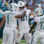 
              Miami Dolphins tight end Cethan Carter (82) is congratulated by quarterback Tua Tagovailoa (1) and wide receiver Jaylen Waddle (17) after Carter scored a touchdown during the first half of an NFL football game against the Houston Texans, Sunday, Nov. 27, 2022, in Miami Gardens, Fla. (AP Photo/Lynne Sladky)
            