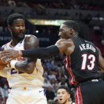 
              Phoenix Suns center Deandre Ayton (22) grabs a rebound as Miami Heat center Bam Adebayo (13) defends during the first half of an NBA basketball game Monday, Nov. 14, 2022, in Miami. (AP Photo/Marta Lavandier)
            