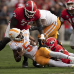 
              Tennessee quarterback Hendon Hooker (5) is sacked by Georgia defensive linemen Tramel Walthour (90) and Nazir Stackhouse (78) during the first half of an NCAA college football game Saturday, Nov. 5, 2022 in Athens, Ga. (AP Photo/John Bazemore)
            