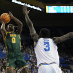 
              Norfolk State guard Christian Ings, left, shoots as UCLA forward Adem Bona defends during the first half of an NCAA college basketball game Monday, Nov. 14, 2022, in Los Angeles. (AP Photo/Mark J. Terrill)
            