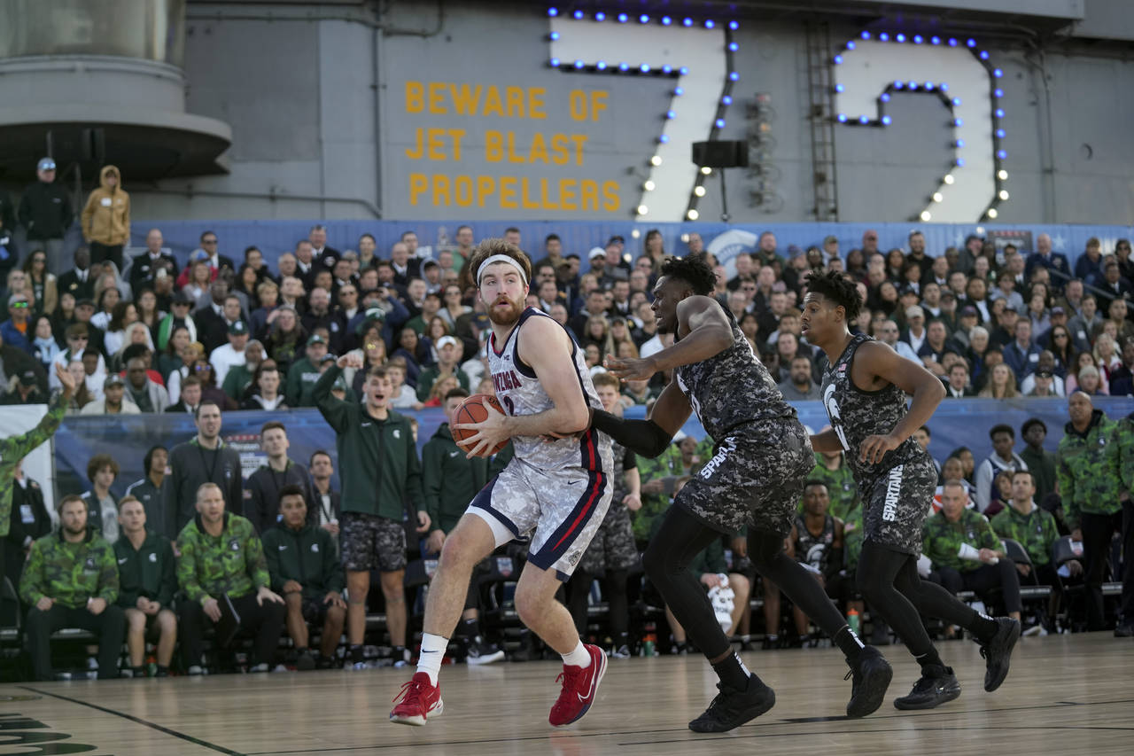 Gonzaga forward Drew Timme, left, drives to the basked at Michigan State center Mady Sissoko defend...