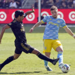 
              Philadelphia Union defender Kai Wagner, right, plays the ball as Los Angeles FC forward Carlos Vela (10) closes in during the first half of the MLS Cup soccer match Saturday, Nov. 5, 2022, in Los Angeles. (AP Photo/Marcio Jose Sanchez)
            