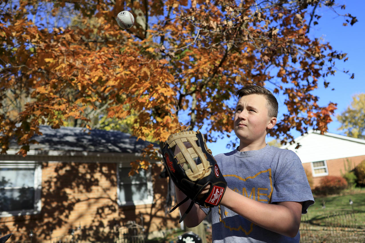 Liam Kennedy tosses a baseball he stands in his family's front yard Friday, Oct. 28, 2022, in Monro...