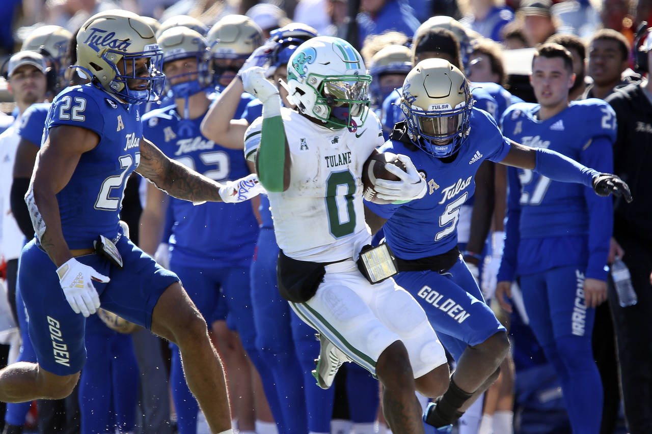Tulane's Shaadie Clayton-Johnson completes a long gain while being forced out of bounds by Tulsa de...