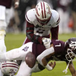 
              Texas A&M wide receiver Moose Muhammad III (7) fumbles the ball after a catch and run as Massachusetts defensive back Tristan Armstrong (8) and Tyler Rudolph (2) defend during the first half of an NCAA college football game Saturday, Nov. 19, 2022, in College Station, Texas. (AP Photo/Sam Craft)
            